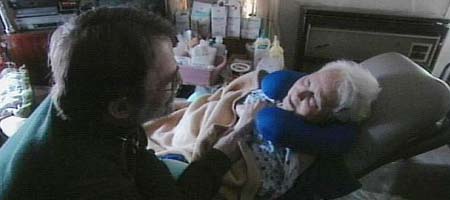 photo of a man taking care of an older woman